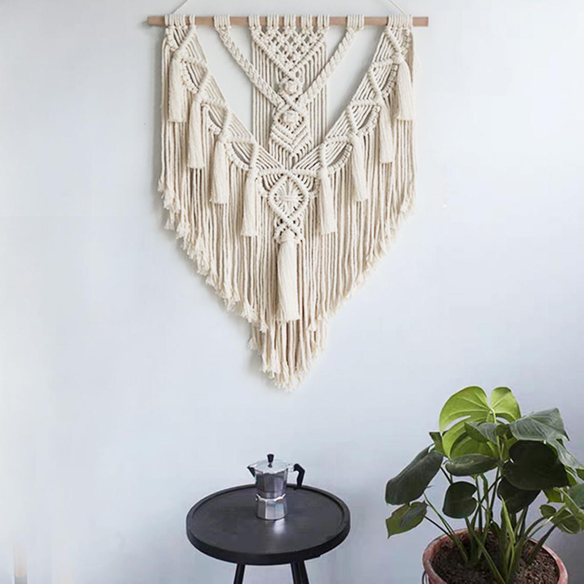 Macramé de parede sobre mesa com moka e planta