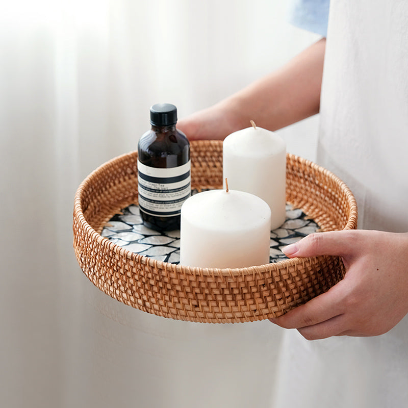 Tabuleiro de rattan com velas, segurado nas mãos