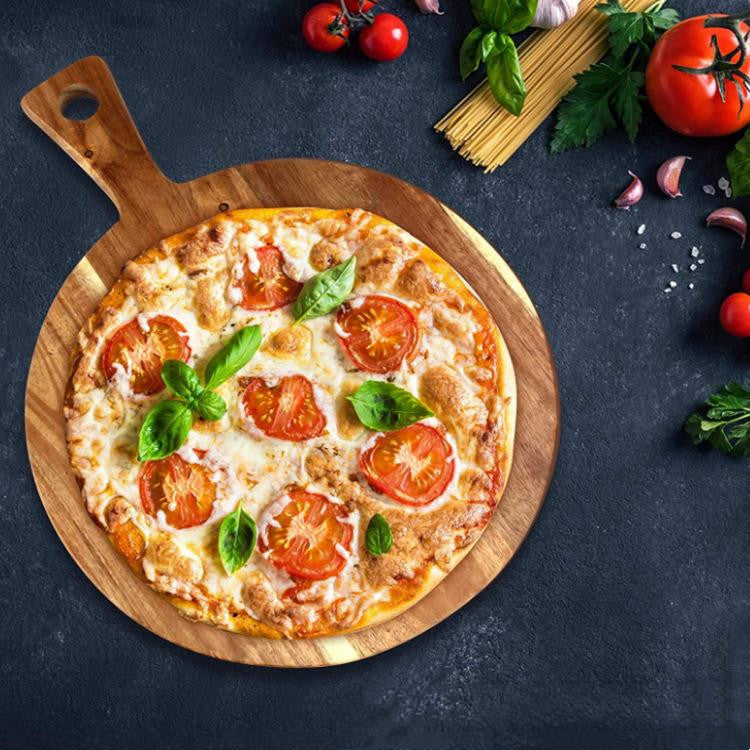 Tábua de acácia a servir uma pizza